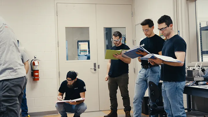 Bootcamp attendees reading through manuals in a workshop